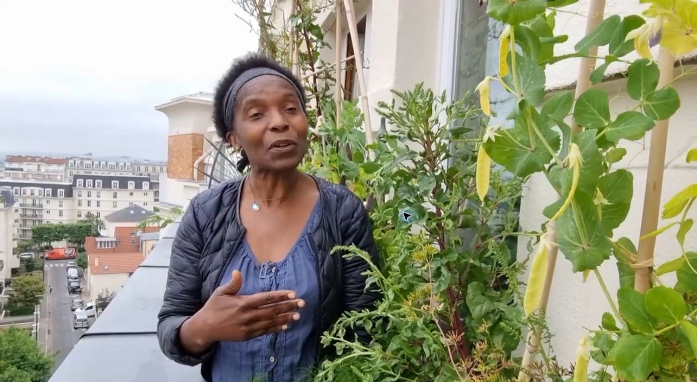 Valéry Tsimba au milieu des cultures sur son balcon, en région parisienne.