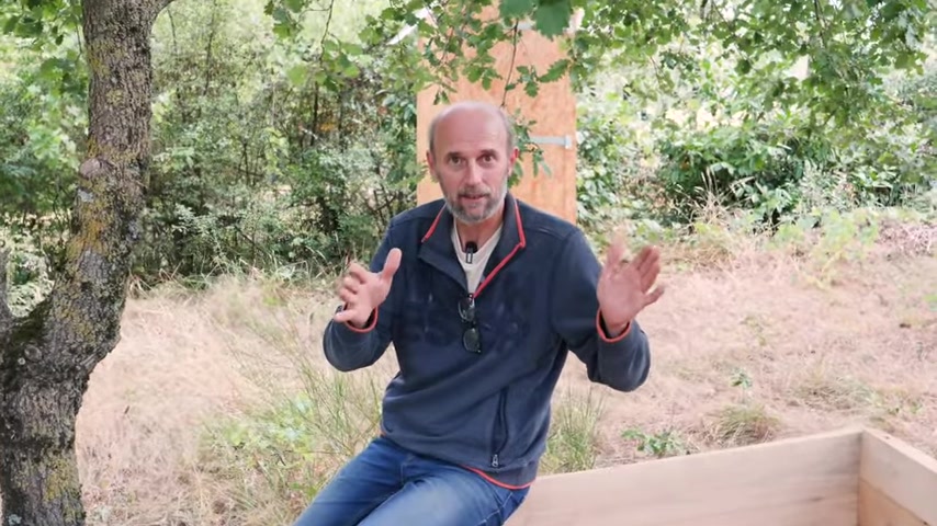 Pierre explique son raisonnement près du bac en bois.