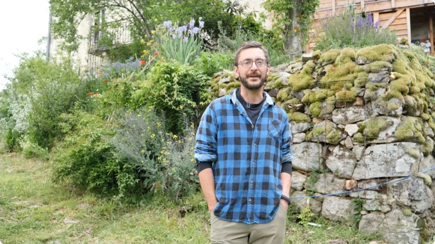 Mathieu accueille Brian devant les bâtiments et les plantations de sa fermette.