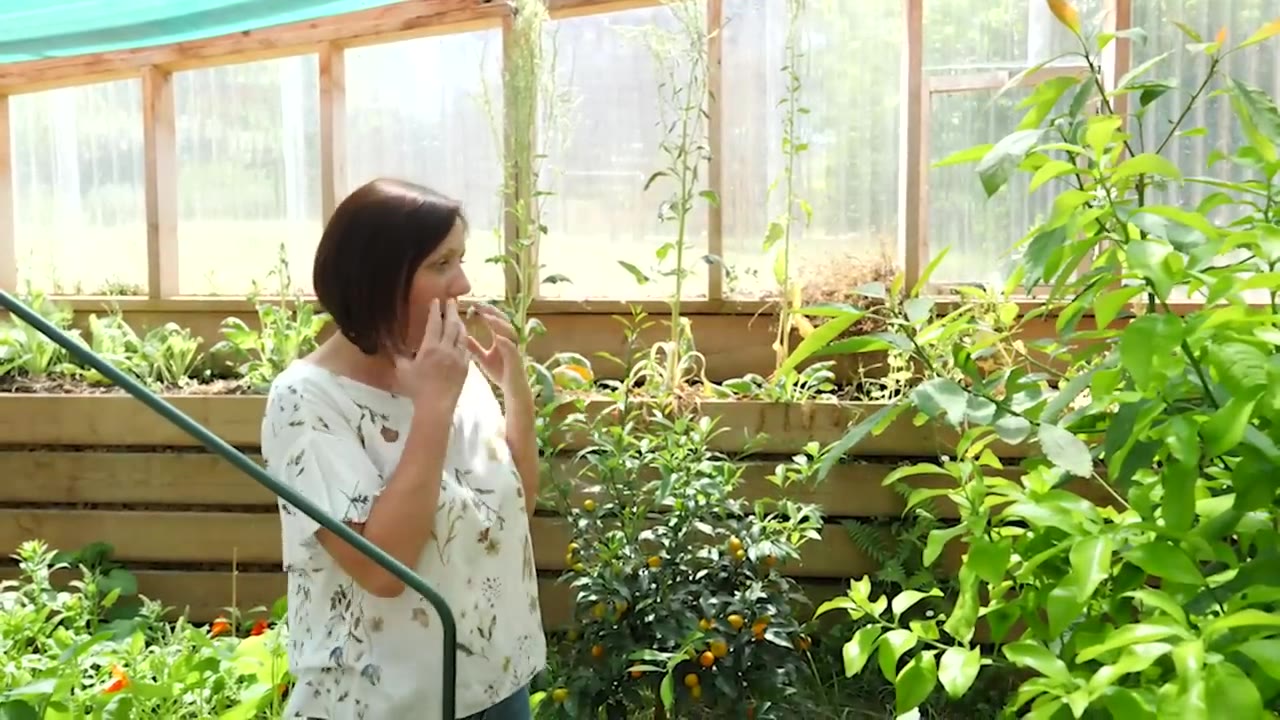Émilie à l’intérieur de la serre parmi les cultures