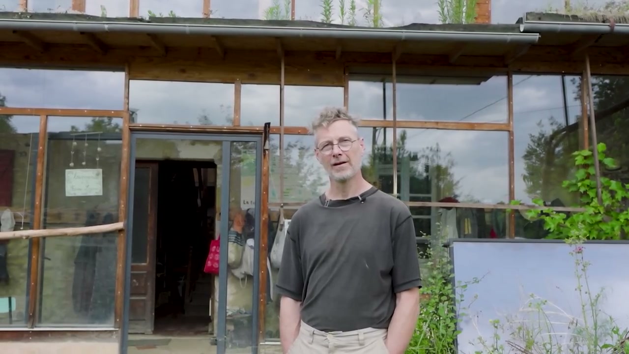 La visite se poursuit devant les vitrages de la maison.