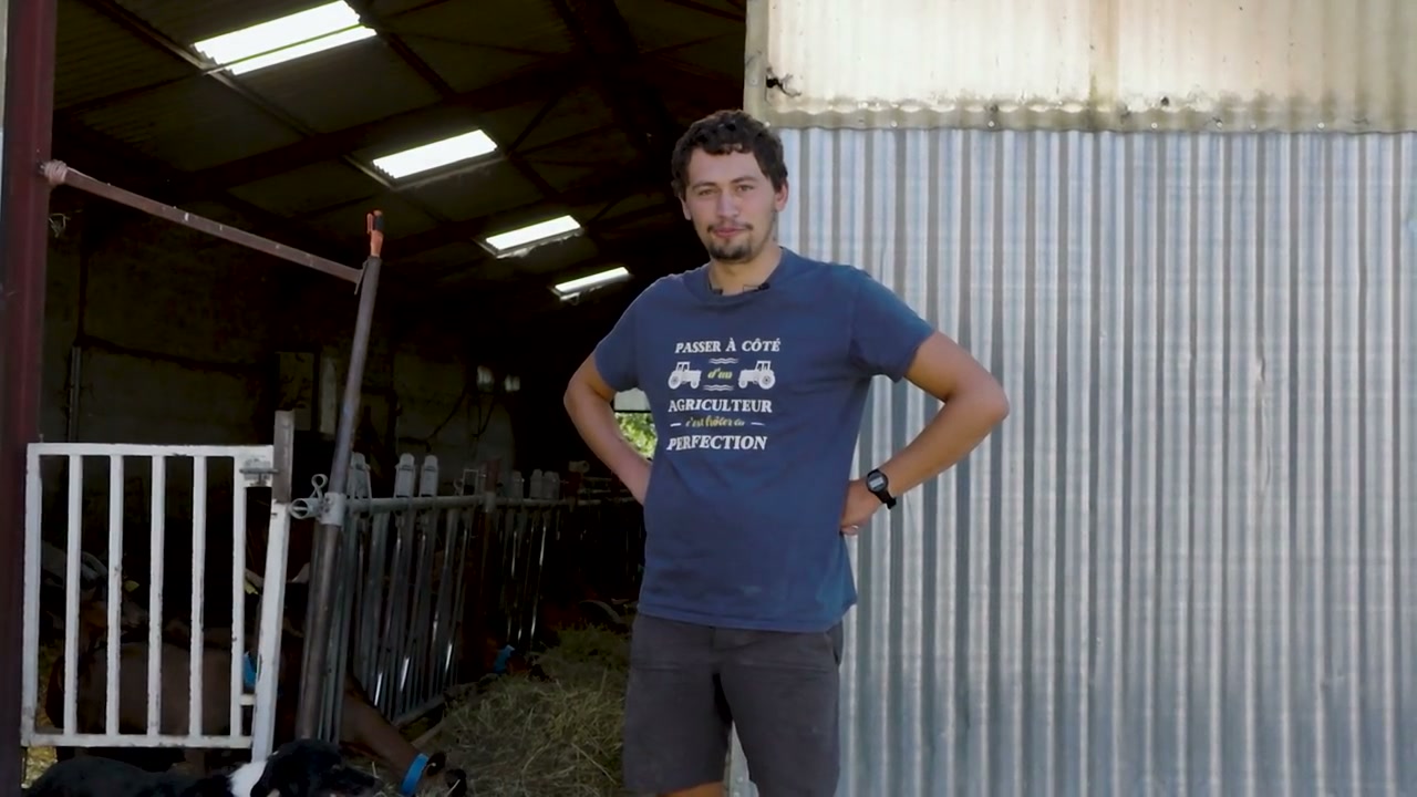 Hugues devant un bâtiment de l’élevage.