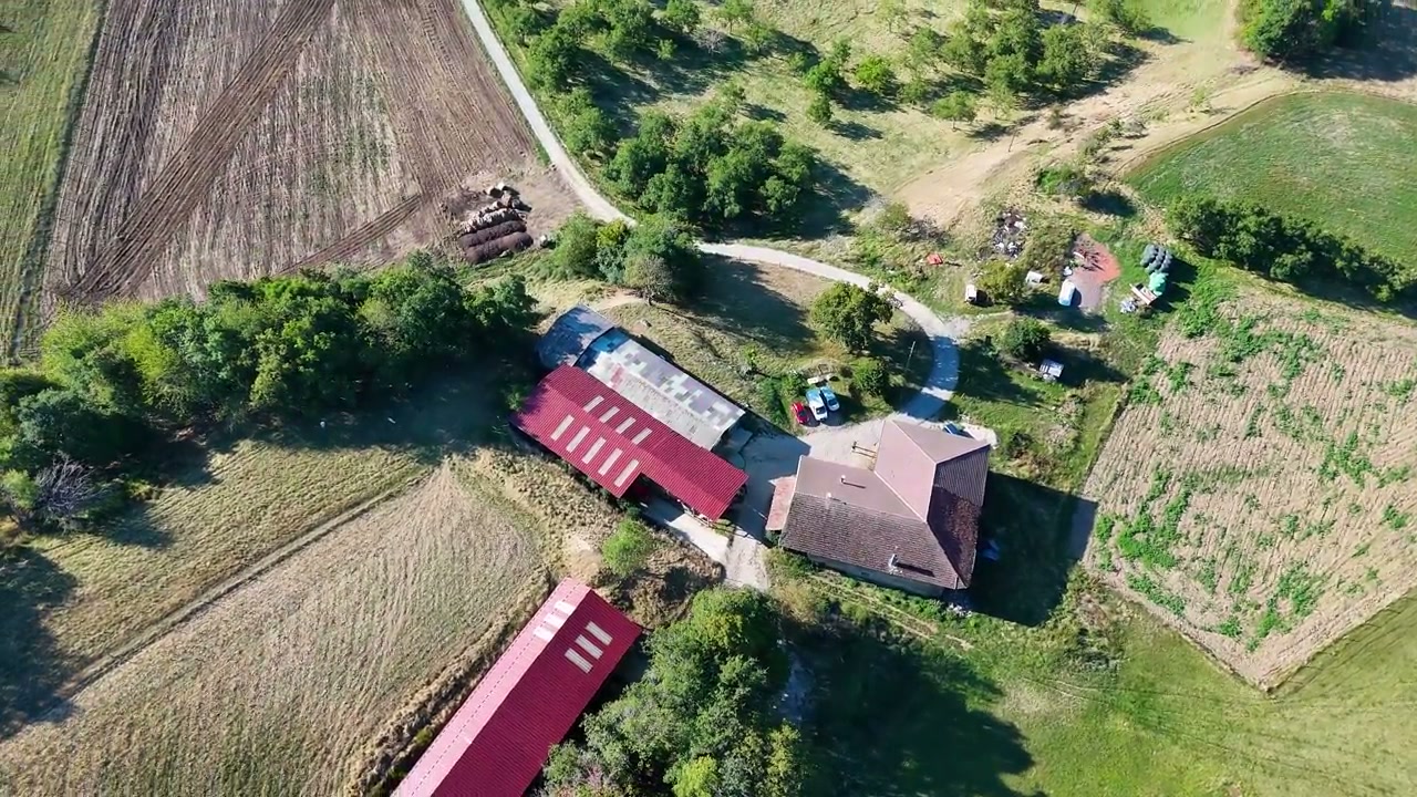Une vue aérienne des bâtiments et des parcelles de la ferme.