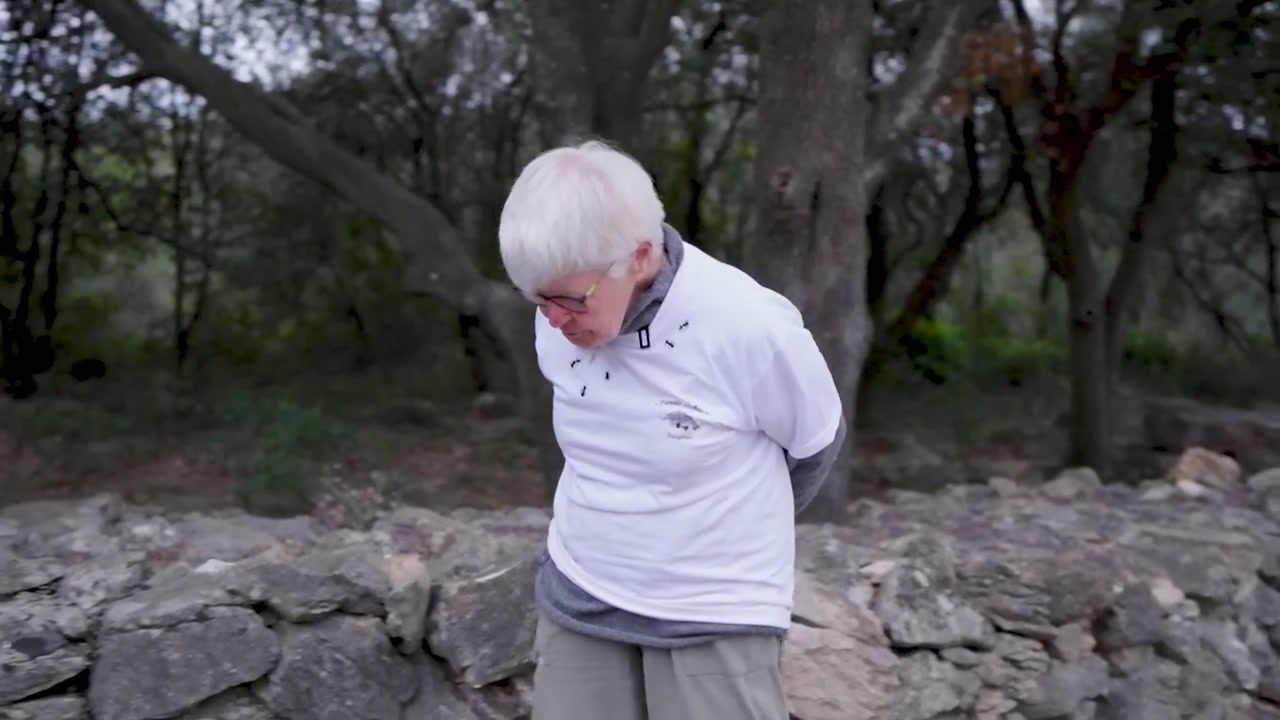 Claude observe un ouvrage en pierre sèche.