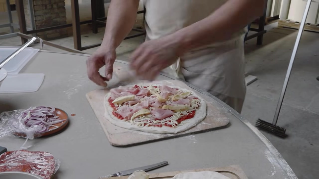Préparation d’une pizza avant son enfournement.
